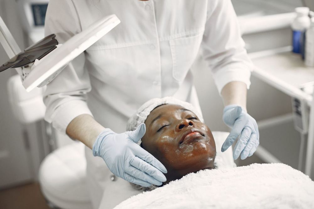 A client receiving a professional facial treatment in a clean, modern skincare clinic.