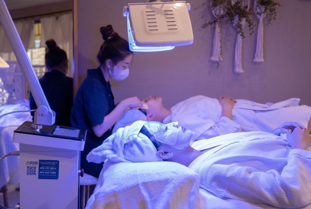 Clients receiving light-based treatments on treatment beds in a calm clinic room.