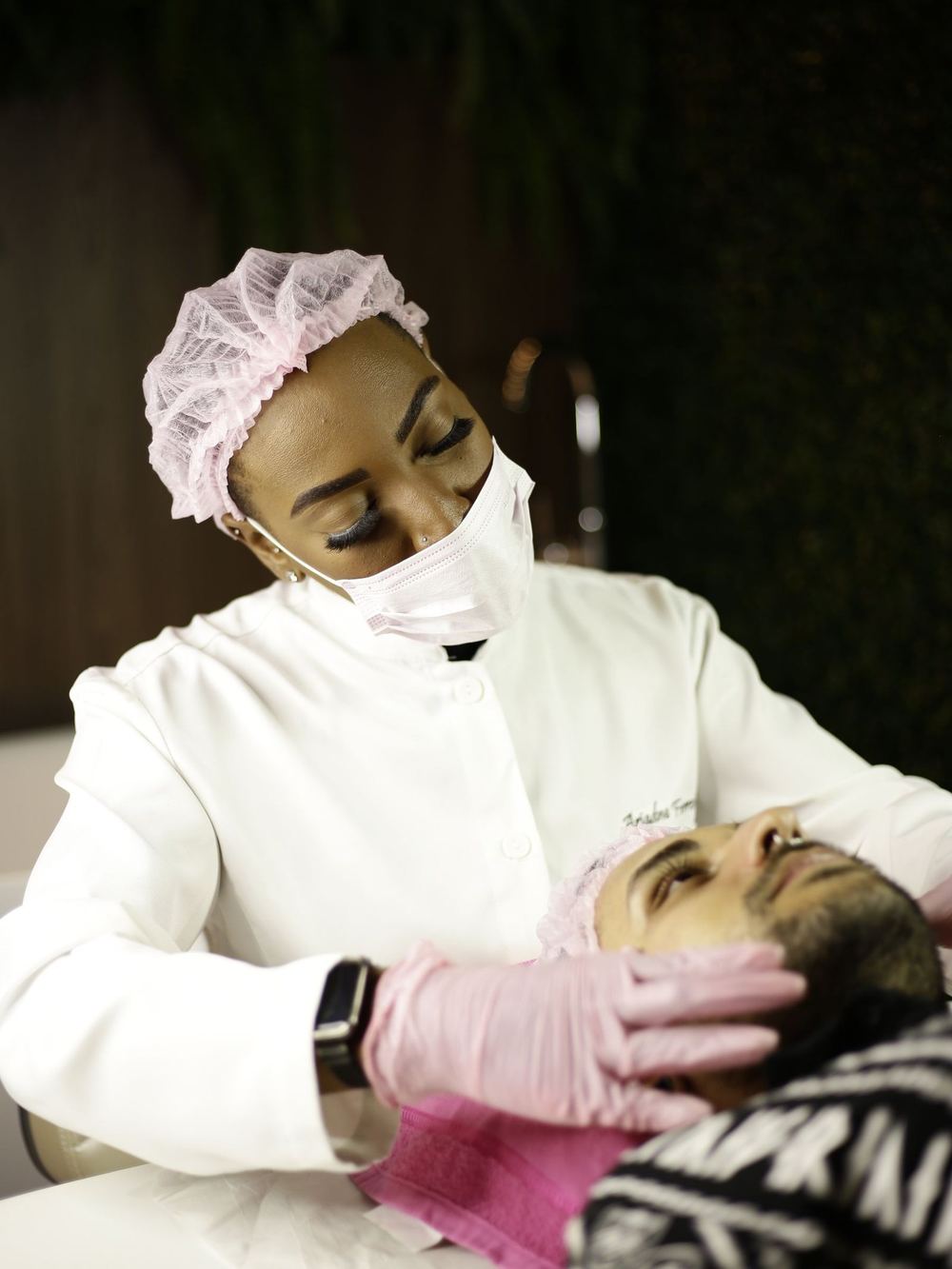 A skin therapist assessing a client's skin during a professional consultation.